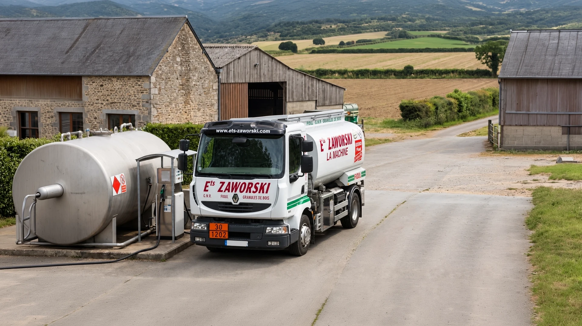 Camion-citerne blanc de livraison stationné sur exploitation agricole, cuve cylindrique et rampe de distribution en place, tracteur en cours de ravitaillement en GNR directement auprès du camion, terrain agricole visible en arrière-plan.